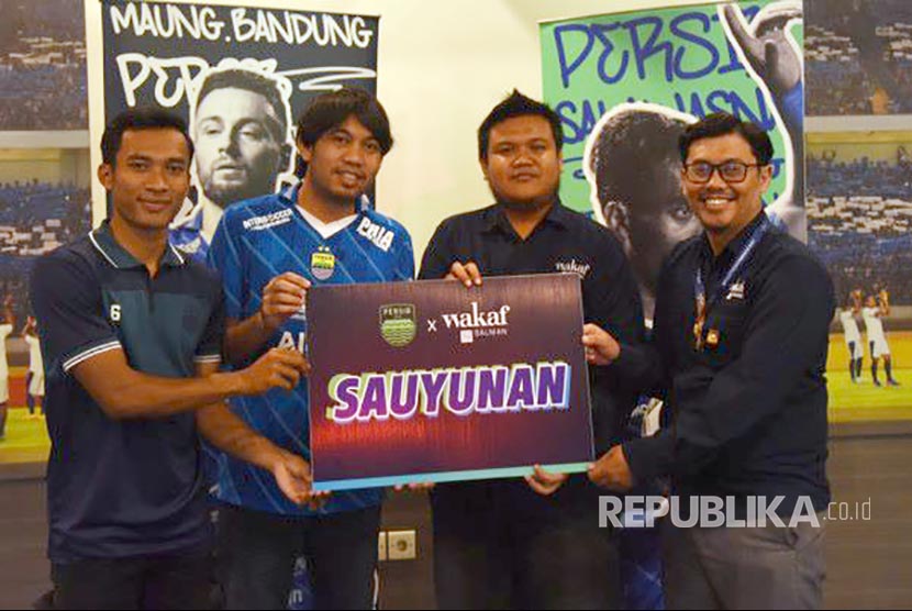 Bek Persib Bandung Robi Darwis (kiri) menyerahkan mockup bantuan pakaian olahraga melalui lembaga Wakaf Salman ITB pada kegiatan Sauyunan di 1933 Dapur & Kopi, Jalan Sulanjana, Kota Bandung, Rabu (5/7/2023).