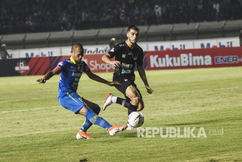 Bek Persib Bandung Supardi (kiri) berebut bola dengan pemain Tira Persikabo saat pertandingan Sepak Bola Liga 1 2019 di Stadion Si Jalak Harupat, Kabupaten Bandung, Selasa (18/6). 