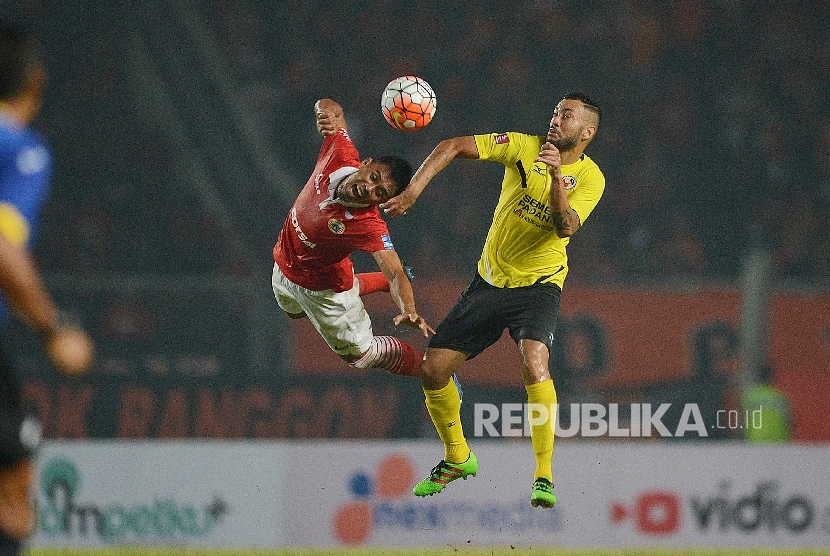 Bek Persija Maman Abdurahaman berebut bola dengan striker Semen Padang Marcel D Sacramento dalam pertandingan Torabika Soccer Championship di Stadion Gelora Bung Karno, Jakarta, Ahad (9/5). Foto: Yogi Ardhi/Republika