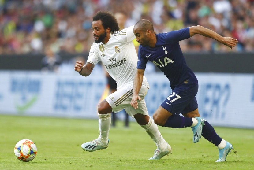 Bek Real Madrid Marcelo (kiri) menjaga gelandang serang Tottenham Hotspur Lucas Moura.