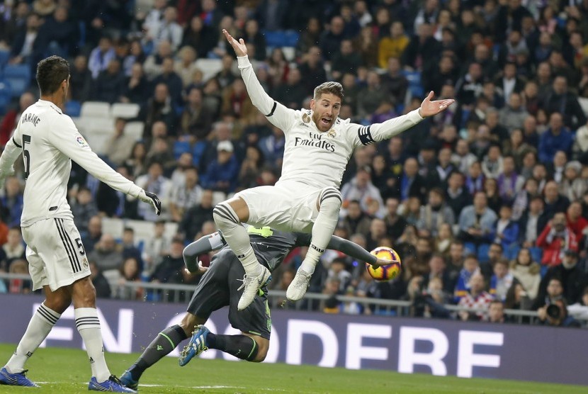 Bek Real Madrid, Sergio Ramos (kanan), melompat berebut bola dengan pemain Real Sociedad, Asier Illarramendi (belakang), dalam laga La Liga Spanyol di Stadion Santiago Bernabeu, Madrid, Spanyol, Ahad (6/1). 