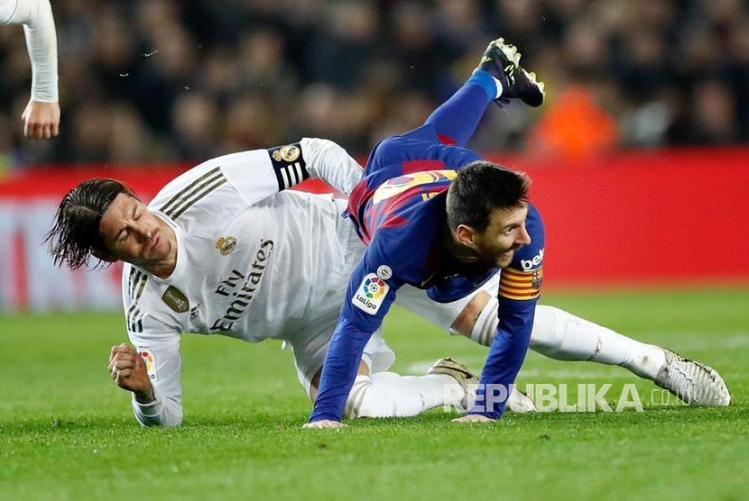 Bek Real Madrid Sergio Ramos mengganjal Lionel Messi  pada laga El Clasico antara FC Barcelona melawan Real Madrid di Camp Nou bulan lalu.