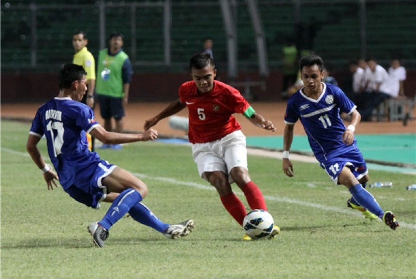  Bek sayap Timnas U-19 Indonesia, Muhammad fatchu Rochman (tengah) berebut bola dengan pesepak bola Filipina saat laga Grup G kualifikasi Piala Asia U-19 2014 di Stadion Utama Gelora Bung Karno, Jakarta, Kamis (10/10). 