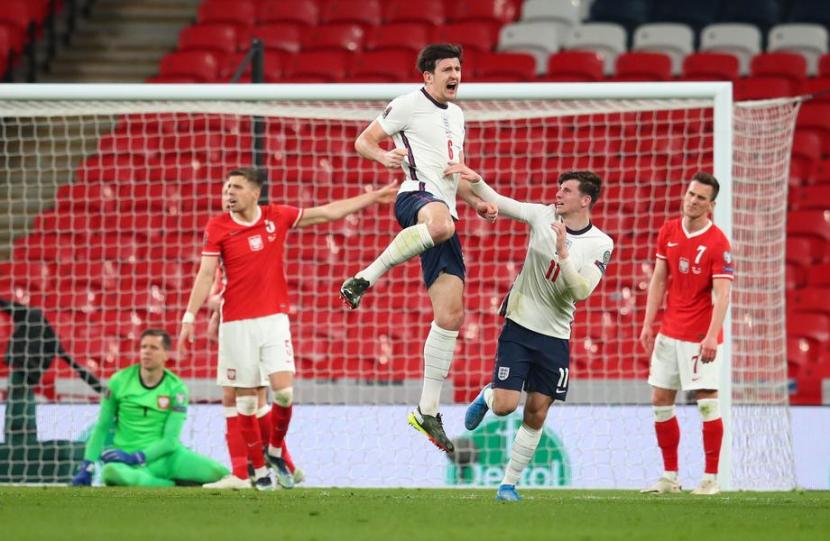 Bek timnas Inggris, Harry Maguire, melompat merayakan golnya ke gawang Polandia. Maguire salah satu pilar pertahanan Inggris di turnamen Euro 2020 UEFA.