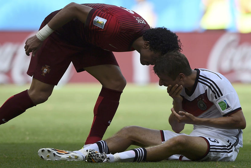 Bek Timnas Portugal, Pepe, menanduk kepala gelandang Jerman, Thomas Mueller (kiri), di laga Grup G Piala Dunia 2014 Brasil di Arena Fonte Nova, Salvador, Senin (16/6). 