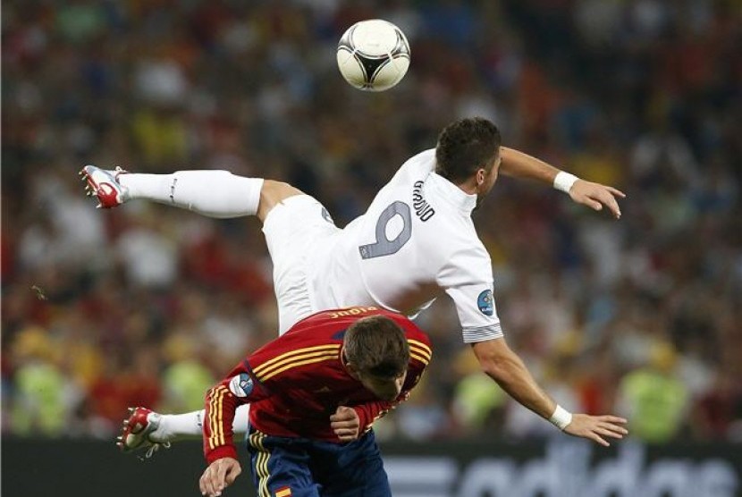 Bek timnas Spanyol, Gerard Pique (bawah), terlibat perebutan bola dengan pemain timnas Prancis, Olivier Giroud, di laga perempat final Piala Eropa 2012. 