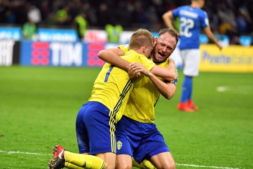 Bek Timnas Swedia, Andreas Granqvist (kanan) dan Sebastian Larsson merayakan keberhasilan timnya lolos ke putaran final Piala Dunia 2018 usai menahan imbang Italia 0-0 di leg kedua babak kualifikasi Zona Eropa di Stadion Giuseppe Meazza, Milan, Italia, Senin (13/11). 