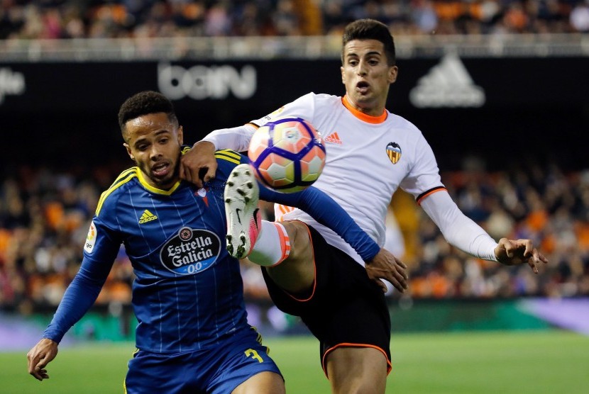 Bek Valencia, Joao Pedro Cavaco (kanan) berebut bola dengan striker Celta Vigo, Theo Bondonga, pada laga La Liga di stadion Mestalla, Kamis (6/4). Valencia menang 3-2.