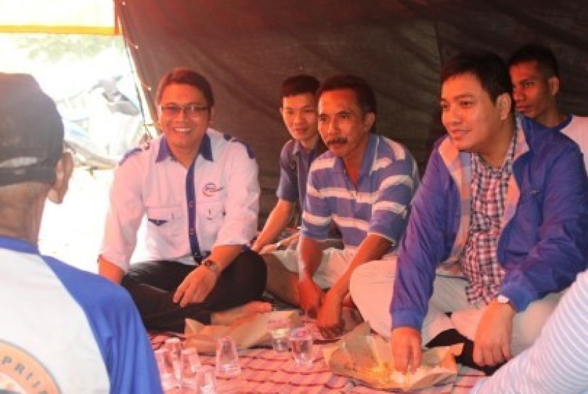 Bendahara Umum DPP PAN, Jon Erizal (kanan) dan Ketua Umum DPP PARRA Indonesia, Rusli Halim Fadli (kiri) makan siang bersama warga di Posko Banjir Jakarta di daerah Cawang Ciliwung Jakarta Timur, Jumat (18/1).