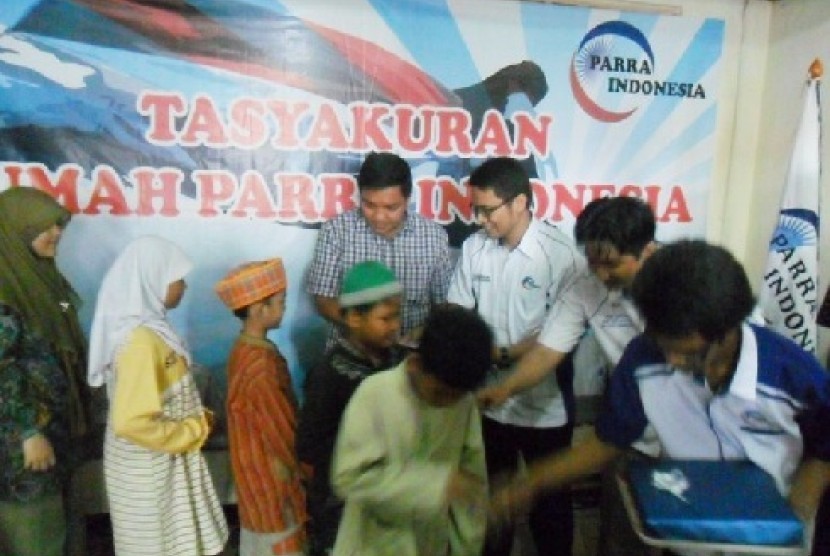 Bendahara Umum DPP PAN, Jon Erizal (kiri) dan Ketua Umum DPP PARRA Indonesia, Rusli Halim Fadli (kedua dari kiri) sedang memberikan bantuan kepada anak yatim piatu.