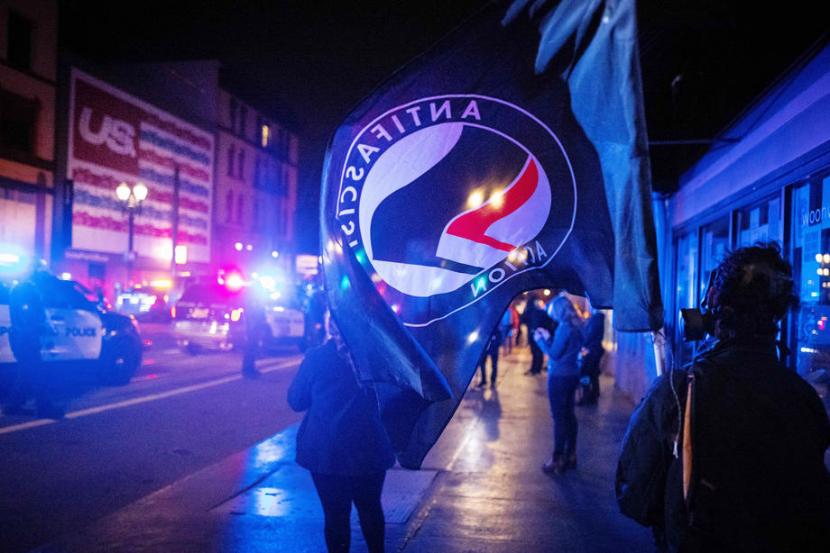 Bendera Antifa di tengah demo pada Rabu (4/11) di Portland. Kepolisian kota Portland melakukan penangkapan dan menyita petasan di malam Pemilu AS. Ilustrasi.