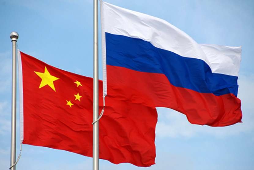Bendera Cina dan Rusia. Angkatan laut Rusia dan Cina mengadakan latihan militer gabungan di Samudra Pasifik.