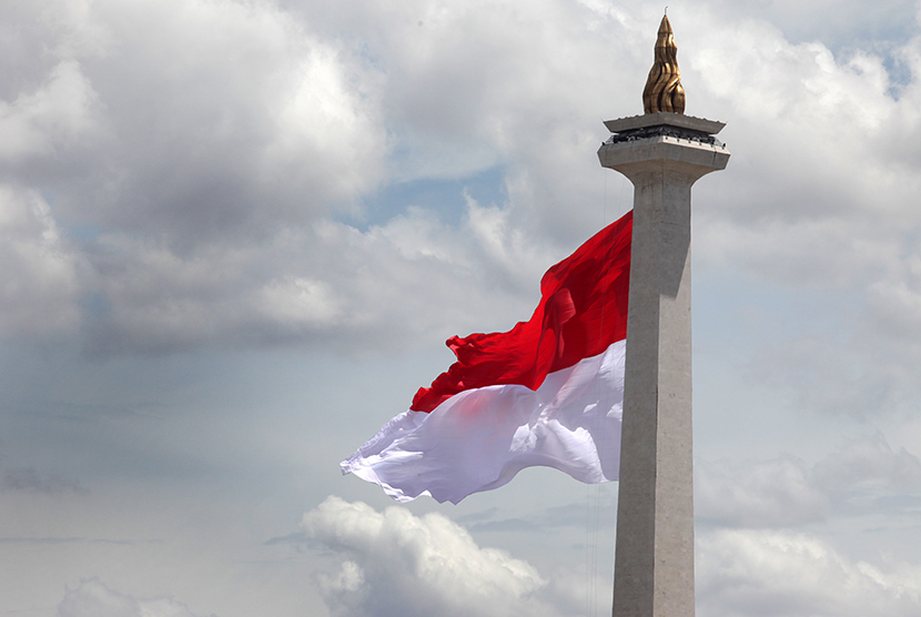 Bendera Merah Putih raksasa berkibar di tugu Monas, Jakarta.  