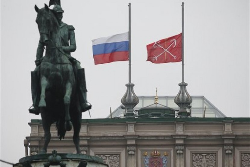 Bendera nasional Rusia (kiri) dan bendera Kota St Petersburg berkibar setengah tiang di belakang patung tsar Rusia Nicholas I di St Petersburg sebagai tanda berkabung atas jatuhnya pesawat Rusia Metrojet di Sinai, Ahad, 1 November 2015. 