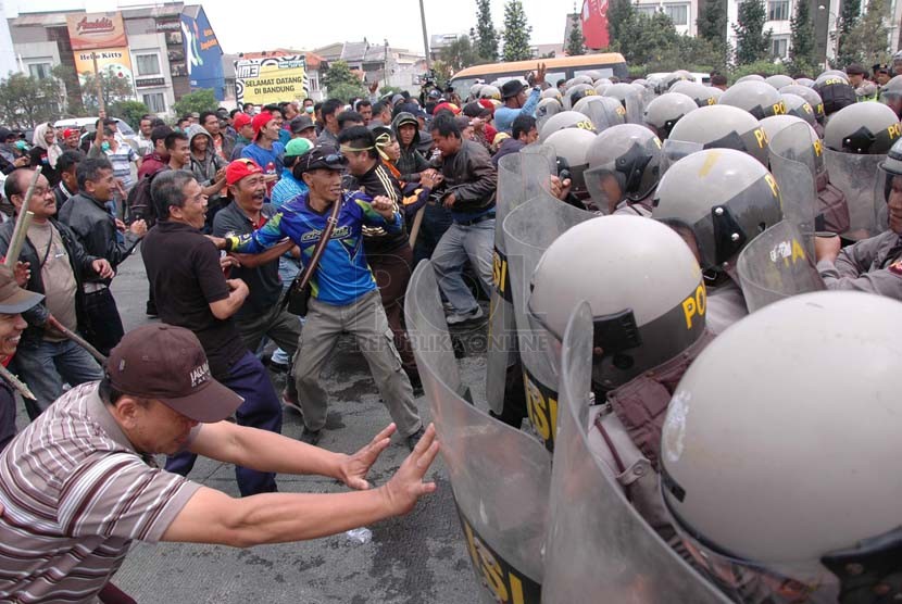 Bentrokan massa di Gerbang Tol Pastur Bandung dengan aparat keamanan pada kegiatan simulasi penyekatan massa menghadapi putusan Mahkamah Konstitusi (MK) dalam sengketa Pilpres 2014, yang digelar Polrestabes Bandung, Senin (18/8). (Republika/Edi Yusuf)