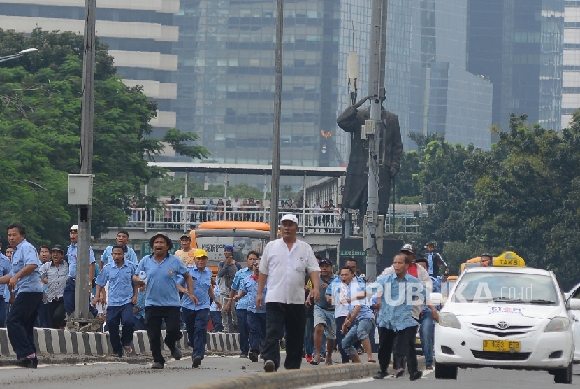 Bentrokan terjadi antara Go-jek dengan supir taxi yang tengah melakukan aksi menutup jalan di Jalan MH.Thamrin, Jakarta Pusat, Selasa (22/3).