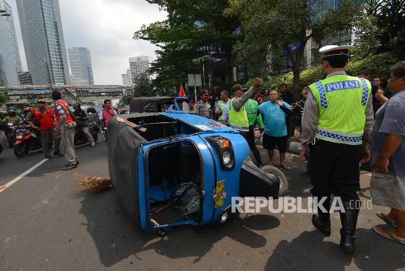 Bentrokan terjadi antara Go-jek dengan supir taxi yang tengah melakukan aksi menutup jalan di Jalan MH.Thamrin, Jakarta Pusat, Selasa (22/3). 