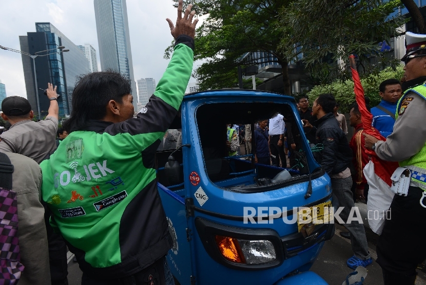 Bentrokan terjadi antara Go-jek dengan supir taxi yang tengah melakukan aksi menutup jalan di Jalan MH.Thamrin, Jakarta Pusat, Selasa (22/3). 