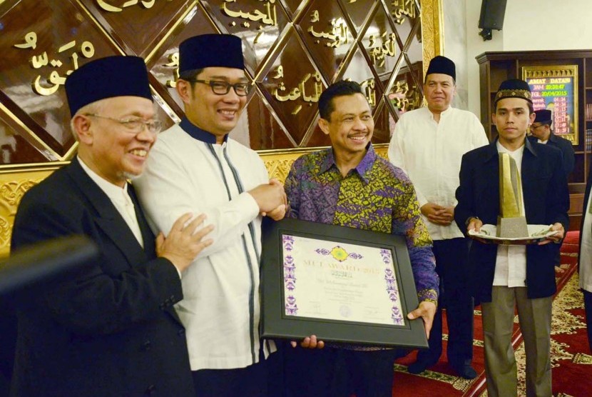 Beri Penghargaan: Ketua MUI Kota Bandung, Miftah Faridl (kiri) di dampingi Wali Kota Bandung, Ridwan Kamil (kedua kiri) memberikan penghargaan kepada Imam Besar Masjid New York USA, Muhammad Shamsi Ali pada acara Silaturahim dan penganugerahan 