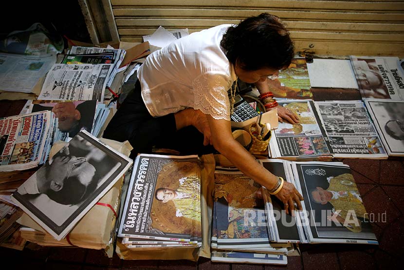 A newspaper agent in Bangkok was tiding up newspapers with the news of King Bhumibol died as headline.
