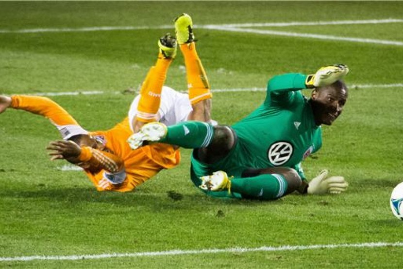 Bill Hamid (kanan), kiper DC United, melakukan aksi penyelamatan gemilang. 