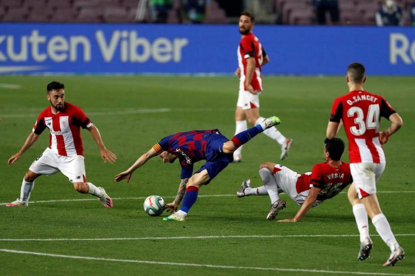 Bintang Barcelona Lionel Messi (tengah) terjatuh dijaga dua pemain Athletic Bilbao. Barcelona mengalahkan Bilbao 1-0 dalam lanjutan La Liga Spanyol lewat gol Ivan Rakitic, Rabu (24/6) dini hari WIB.