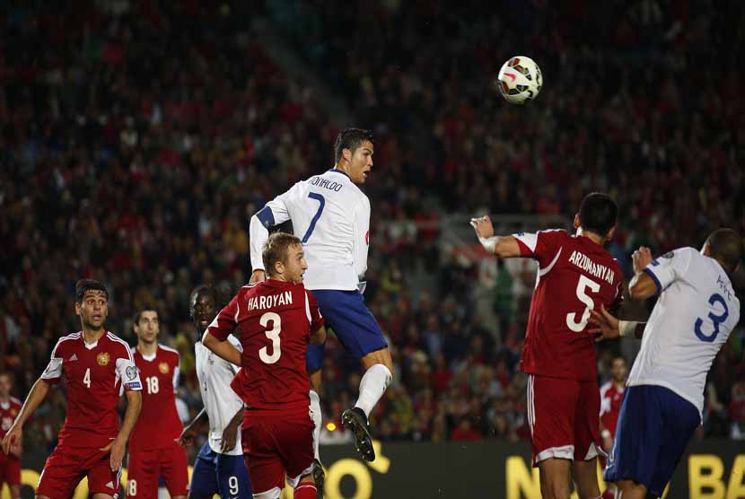 Bintang Timnas Portugal, Cristiano Ronaldo (tengah), melepaskan sundulan di tengah kepungan pemain Armenia di laga Grup I kualifikasi Piala Eropa 2016 di Stadion Algarve, Faro, Jumat (14/11). 