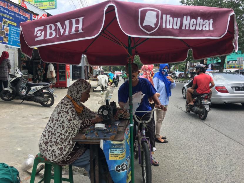 BMH memberikan bantuan tenda payung kepada penjahit yang mangkal di piggir jalan Kota Medan.