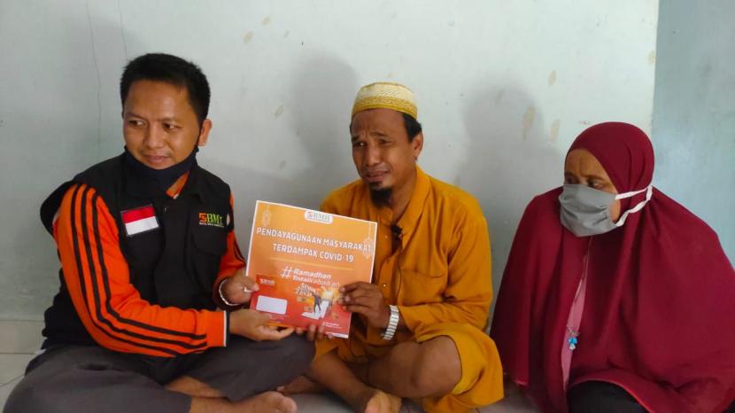 BMH Perwakilan Riau menyerahkan bantuan biaya dan sembako kepada Erman Ritonga (tengah).