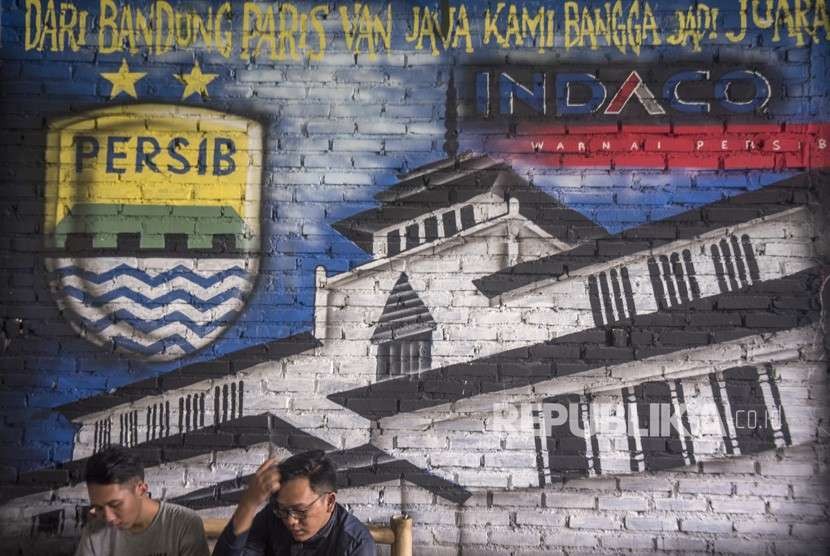 Bobotoh alias pendukung Persib berbincang di depan mural Persib di Bandung, Jawa Barat, Selasa (2/10). 