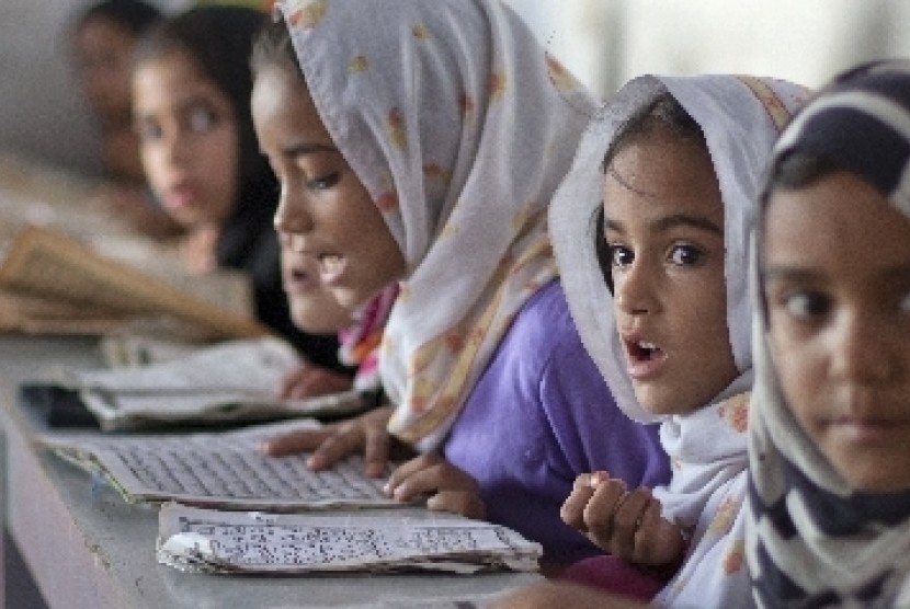 Bocah-bocah Pakistan ini tengah belajar menghapal Alquran di sebuah madrasah di Islamabad.