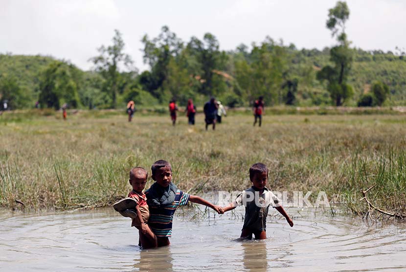 Bocah pengungsi Rohingya melintasi rawa dalam upayanya mengungsi ke wilayah Bangladesh.