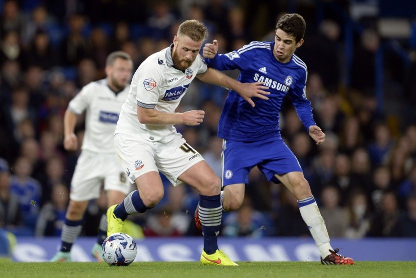 Bolton Wanderers' Matt Mills fights for the ball with Chelsea's Oscar (R) during the English League Cup soccer match at Stamford Bridge in London September 24, 2014.