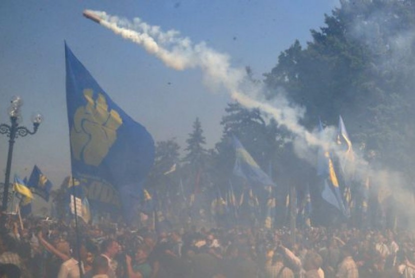 Bom asap dan granat dilemparkan ke arah polisi dalam kerusuhan menentang undang-undang desentralisasi di Kiev, Ukraina, Senin (31/8).