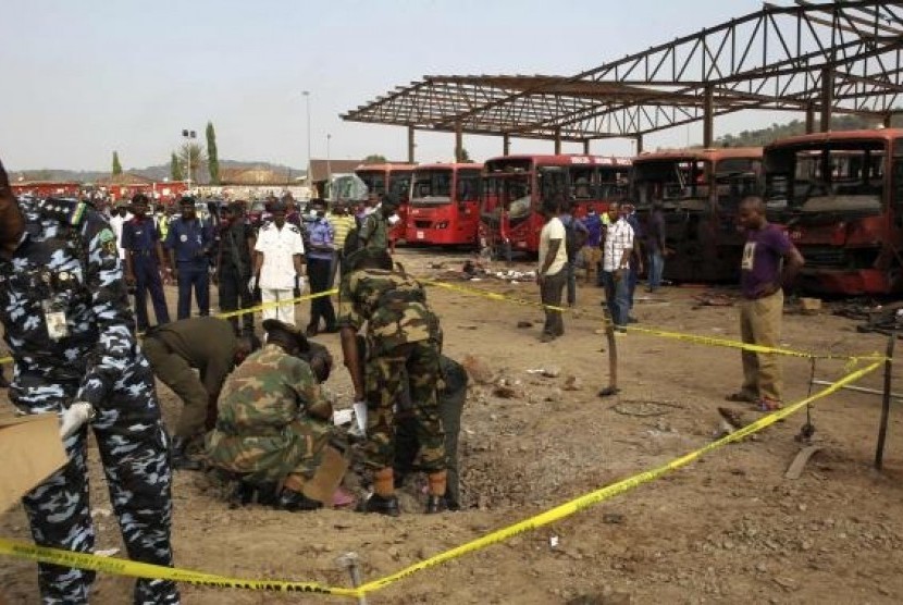 Bomb experts gather evidence in a crater that was caused by a bomb blast explosion at Nyanyan, Abuja April 14, 2014.