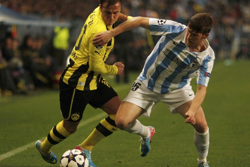 Bomber Borussia Dortmund Mario Goetze berebut bola dengan bek Malaga Vitorino Antunes pada leg pertama perempat final Liga Champions di Stadion La Rosaleda, Kamis (4/4) dini hari WIB.