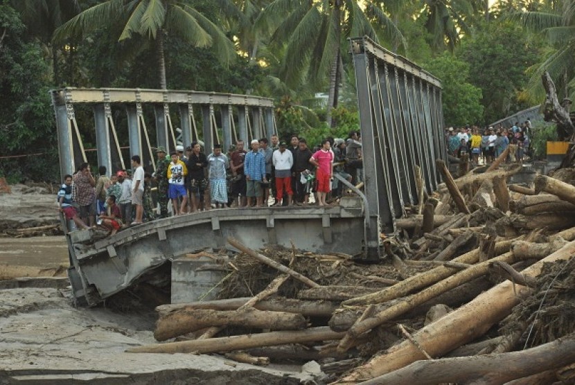 Boyangtongo bridge is cut in the middle as flash floods hit the river in Parigi Moutong, Central Sulawesi, on Saturday night.    