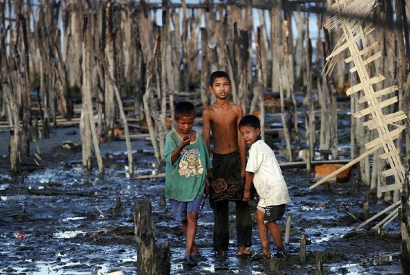 Boys walk through mud carrying items salvaged from the ruins of the burned neighbourhood in East Pikesake ward in Kyaukphyu November 5, 2012. Picture taken November 5.  