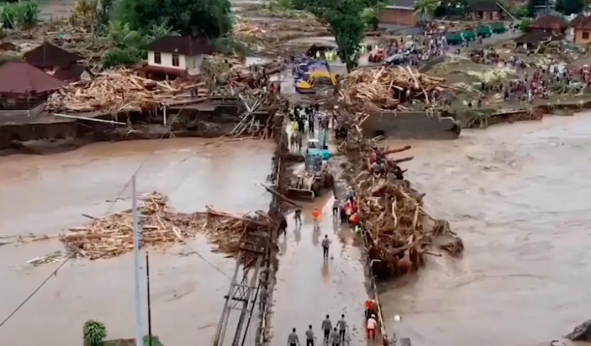 BPBD Provinsi Bali membersihkan bongkahan kayu dan lumpur pascabanjir bandang yang terjadi di Jembarana, Bali.