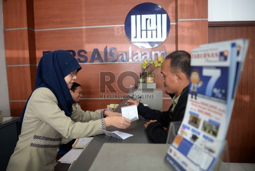 BPRS Satu Kompartemen: Karyawan melayani nasabah di Bank Perkreditan Rakyat Syariah (BPRS) Al Salaam, Jakarta, Rabu (22/4). (Republika/ Yasin Habibi.)