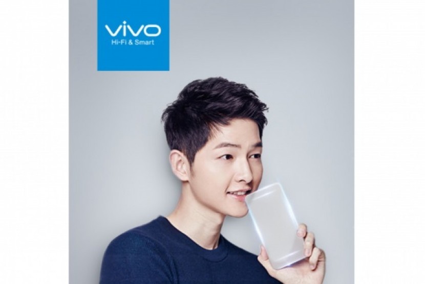 Brand Ambassador Vivo, Song Joong Ki tengah berpose dengan smartphone tembus pandang. 