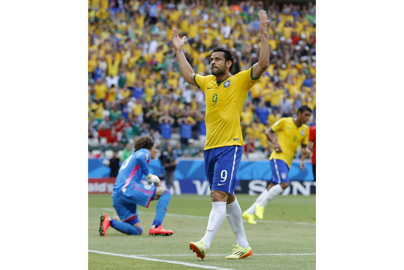 Brazil's Fred, right, reacts after missing a scoring opportunity on Mexico's goalkeeper Guillermo Ochoa, left, during the group A World Cup soccer match between Brazil and Mexico at the Arena Castelao in Fortaleza, Brazil, Tuesday, June 17, 2014.