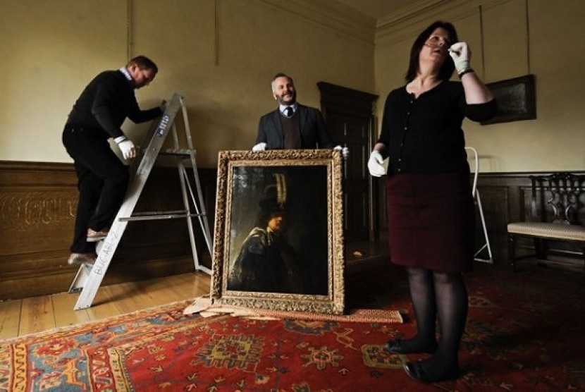 Buckland Abbey staff prepare to hang a recently confirmed self-portrait of Rembrandt, discovered at the Devonshire Abbey in Skipton, England, in this photo dated Wednesday March 13, 2013. 