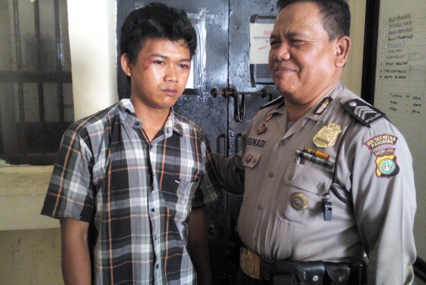 Budi (kiri), sopir Kopaja 612, diamankan pihak kepolisian karena menabrak pengendara Gojek hingga tewas di Warung Buncit, Jakarta Selatan, Rabu (16/9).