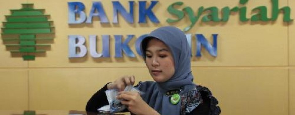 A bank teller works behind a counter at Bukopin Syariah office in Jakarta. (File photo)