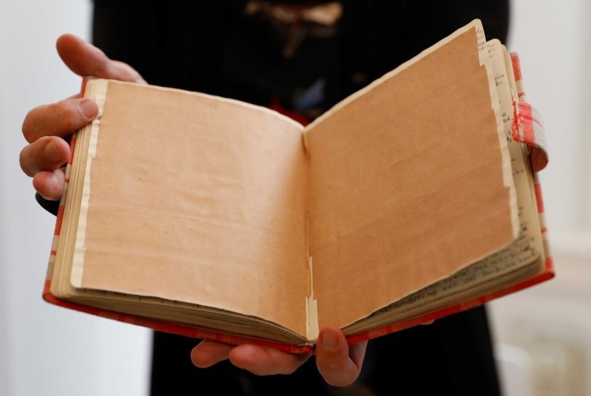 Buku harian Anne Frank yang asli diperlihatkan. Tampak halaman yang sengaja ditutup dengan kertas cokelat.
