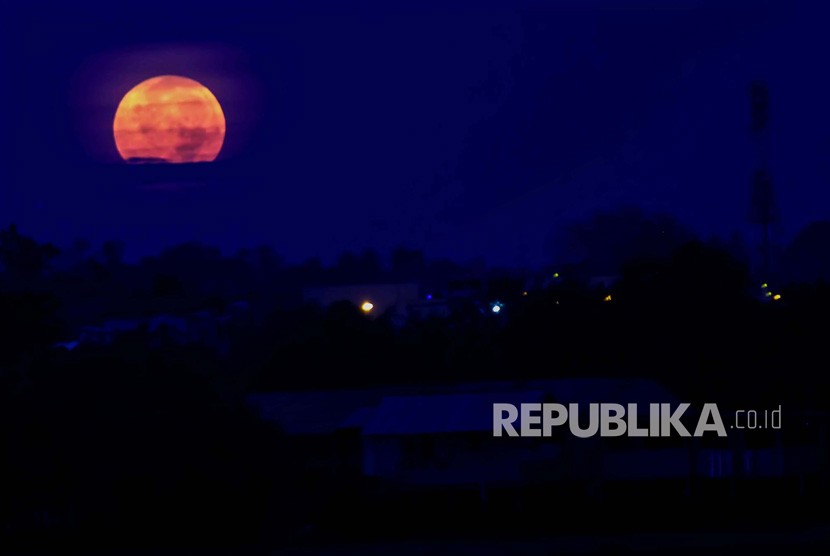 Bulan purnama terang memerah dan besar saat fajar jelang terjadi gerhana bulan dan fenomena Supermoon terlihat diatas langit Kota Lhokseumawe, Aceh, Senin (21/1/2019). 