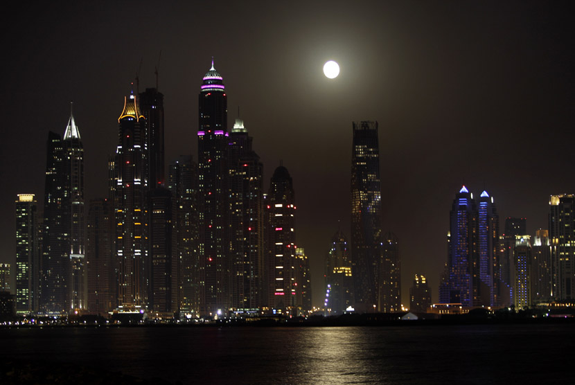 Bulan super moon terlihat di kasawan Marina, Dubai, Ahad (23/6).    (AP/Kamran Jebreili)