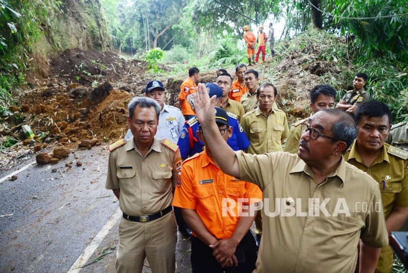 Bupati Bandung Barat Abu Bakar meninjau longsor yang menutupi jalan, di Jalan Kol Masturi, Kecamatan Lembang, Kabupaten Bandung Barat, Senin (12/11). Longsor tersebut memutus jalur Lembang-cimahi.  