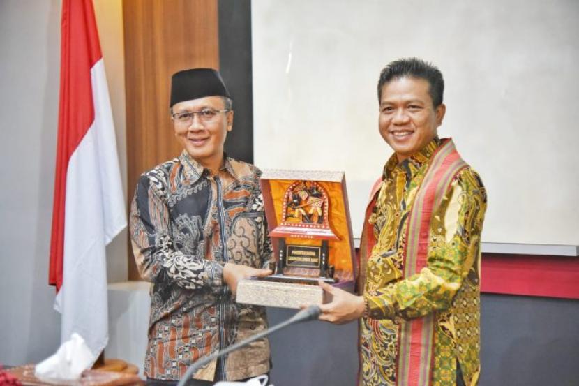 Bupati Bandung Dadang Supriatna (kanan) dan Bupati Lombok Barat Fauzan Khalid bertukar cinderamata di ruang pertemuan Bupati Lombok Barat, Selasa (30/11).